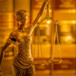 Legal law concept image, books and scale of justice lit by golde