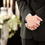 Close up of folded hands at funeral service